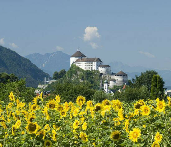 Foto: Festung Kufstein mit Sonnenblumen in vordergrund.